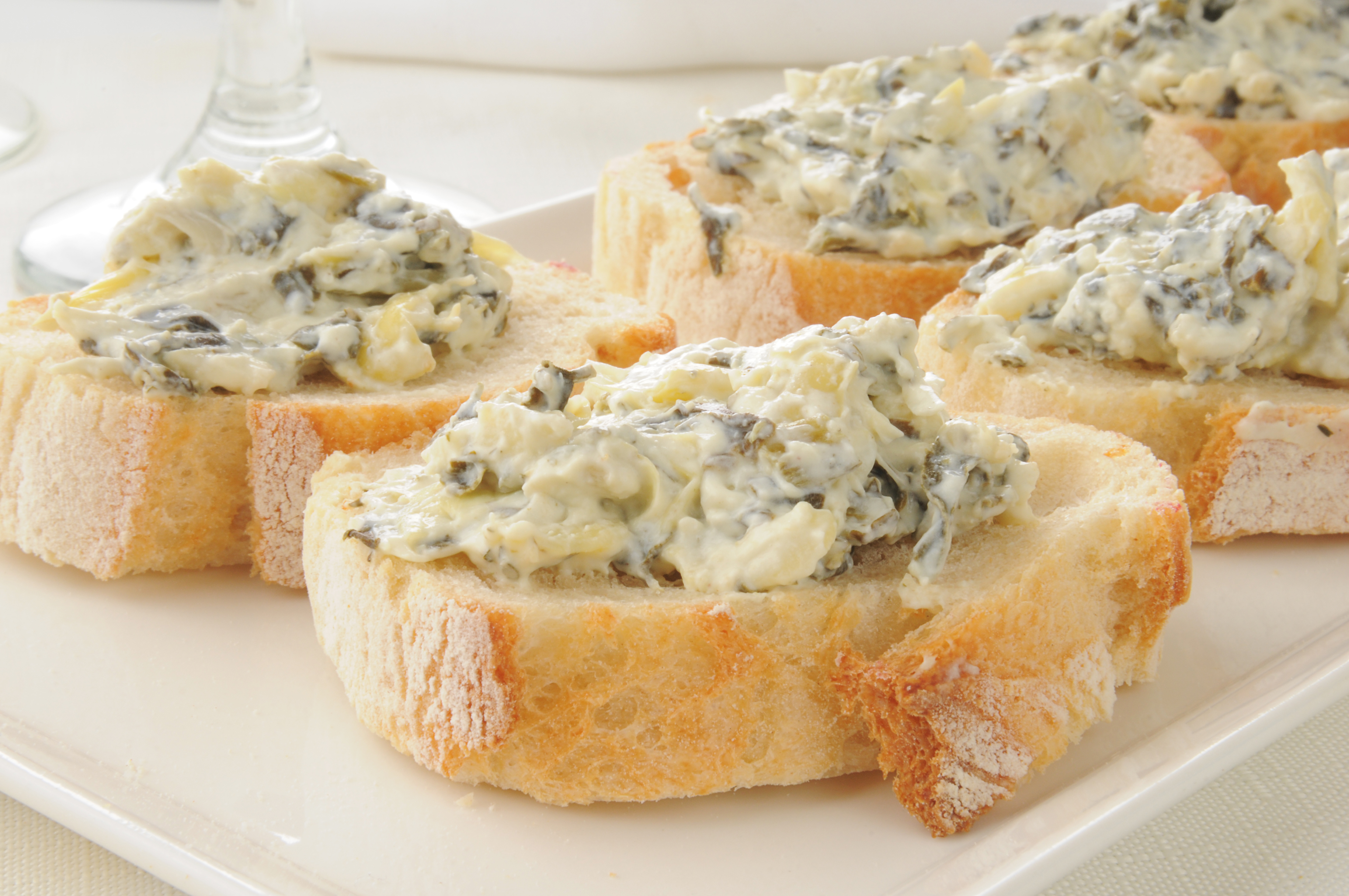 Weight Watchers Artichoke Dip on top of small pieces of bread.