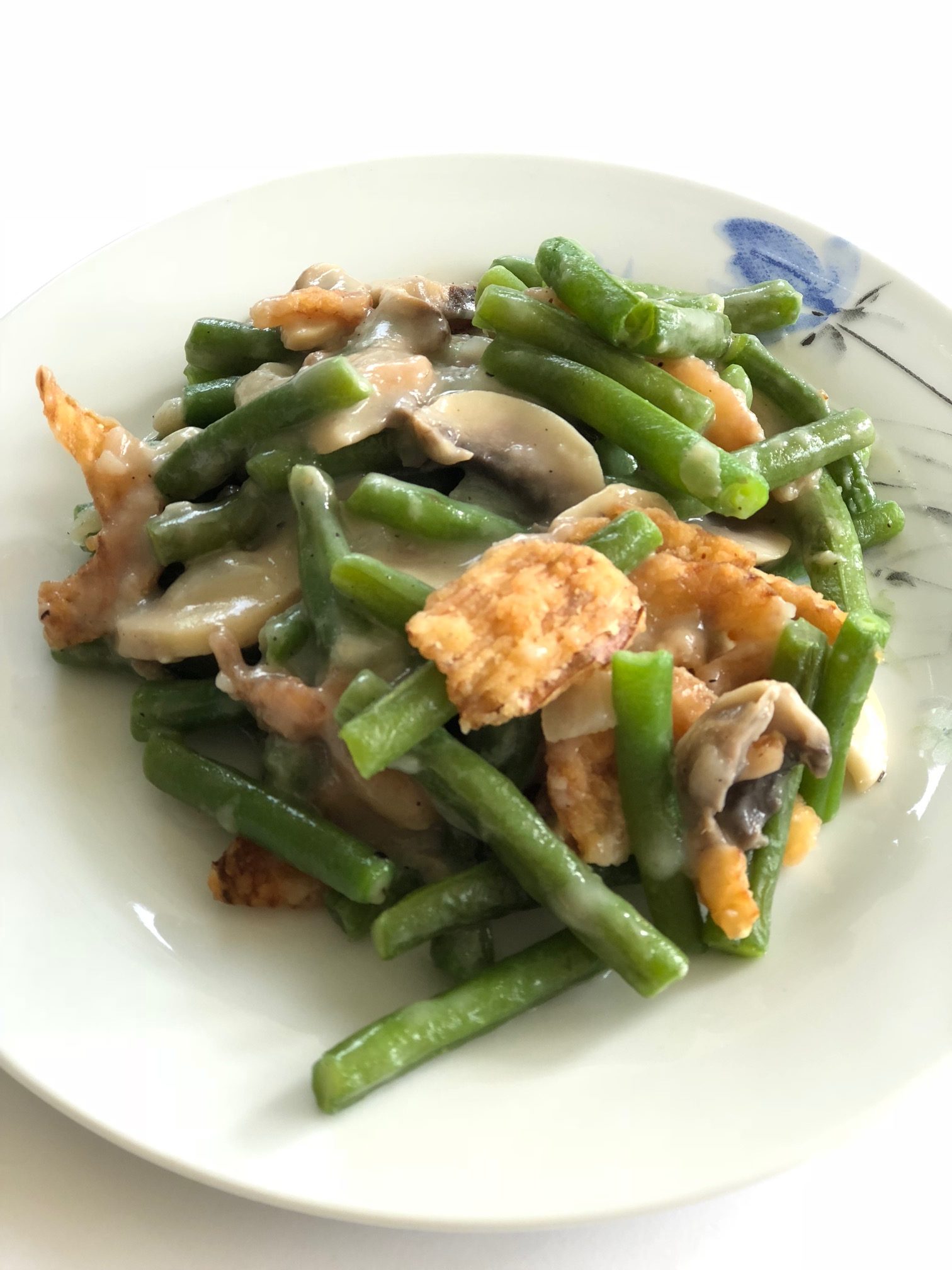 Weight Watchers Green Bean Casserole set on white place, topped with friend onions.