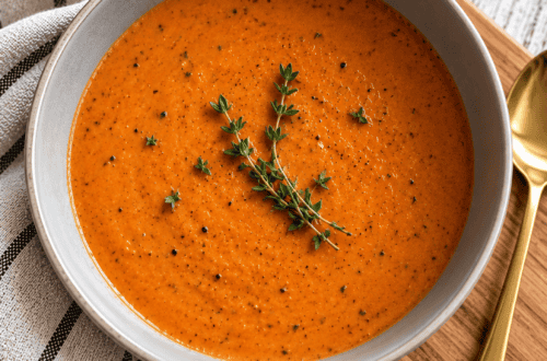 Creamy tomato basil dill soup made with roasted Roma tomatoes, fresh basil, and dill, served in a rustic bowl.