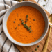 Creamy tomato basil dill soup made with roasted Roma tomatoes, fresh basil, and dill, served in a rustic bowl.