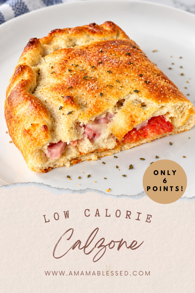 A freshly baked low calorie calzone topped with oregano sits on top of a white plate. 