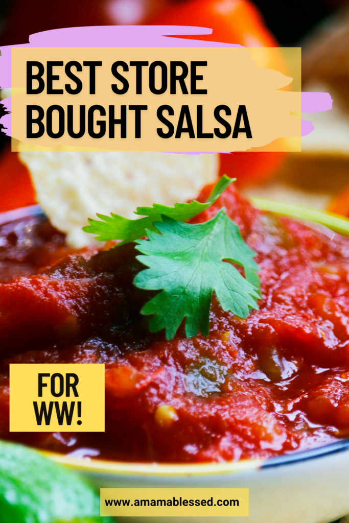 A close up of fresh salsa in a bowl on a table topped with cilantro leaves.