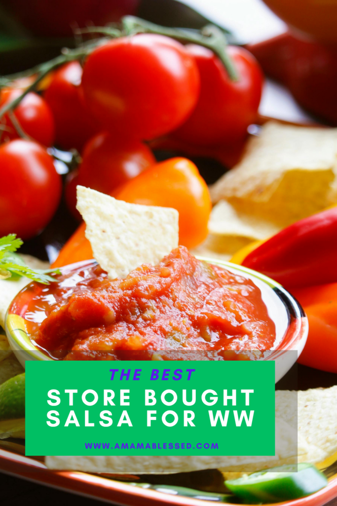 A small bowl of fresh salsa with a tortilla chip in the middle sits on a serving tray.