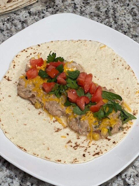 Weight Watchers Fiesta Chicken Recipe sits on a tortilla topped with various toppings.